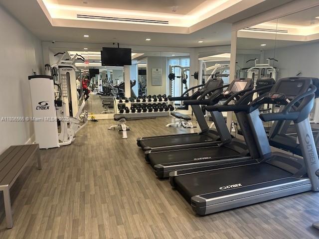 19500 Turnberry Way Unit 12A, Aventura, FL 33180 - exercise room featuring a tray ceiling and wood finished floors