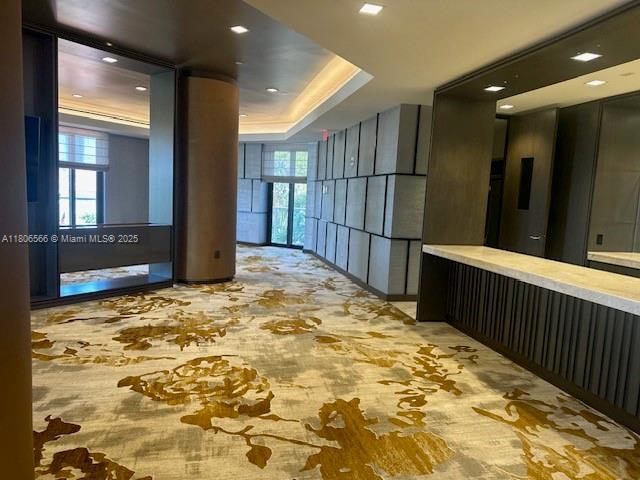 19500 Turnberry Way Unit 12A, Aventura, FL 33180 - hallway featuring plenty of natural light, carpet flooring, and a raised ceiling