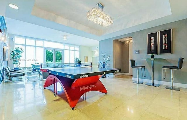 15051 Royal Oaks Ln Unit 1703, North Miami, FL 33181 - recreation room featuring a tray ceiling, baseboards, and a chandelier