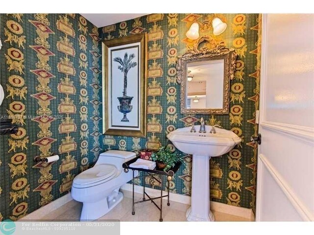 2100 N Ocean Blvd Unit 5B, Fort Lauderdale, FL 33305 - bathroom featuring wallpapered walls, toilet, and baseboards