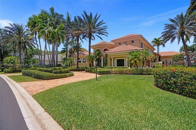 10233 NW 66th Dr, Parkland, FL 33076 - mediterranean / spanish house with stucco siding, a tile roof, and a front yard