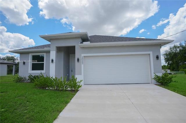 2022 Granada Rd, La Belle, FL 33935 - prairie-style house with stucco siding, driveway, an attached garage, a front yard, and roof with shingles