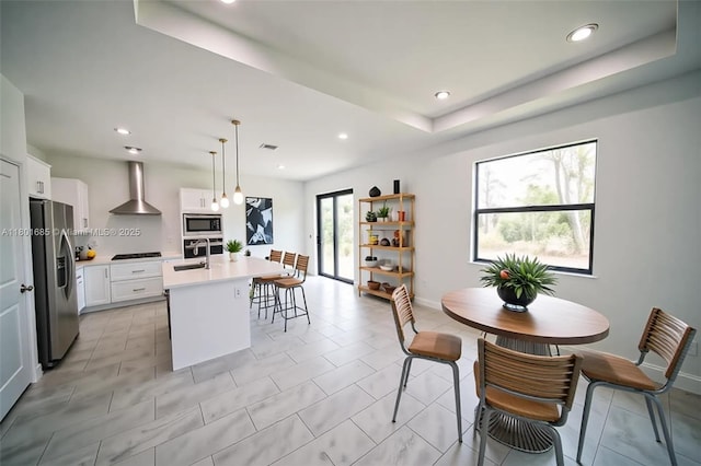 2022 Granada Rd, La Belle, FL 33935 - kitchen featuring wall chimney range hood, appliances with stainless steel finishes, a sink, light countertops, and a kitchen island with sink