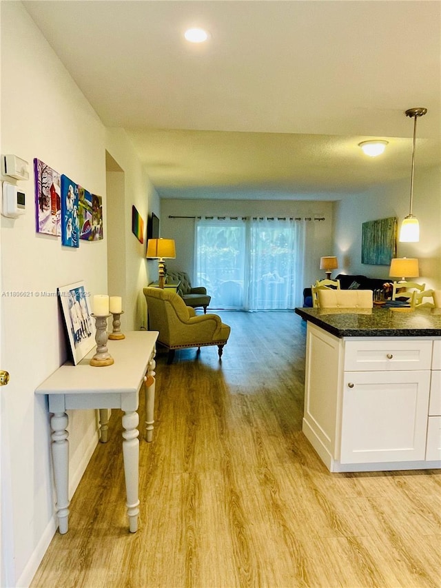 1000 Hillcrest Ct Unit 111, Hollywood, FL 33021 - kitchen with light wood-style flooring, open floor plan, white cabinetry, decorative light fixtures, and baseboards