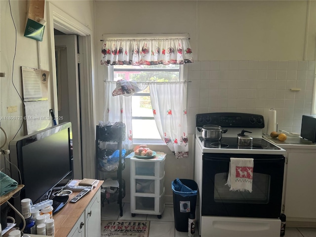 1527 NW 101st St, Miami, FL 33147 - kitchen with electric range, light tile patterned floors, white cabinetry, and wooden counters