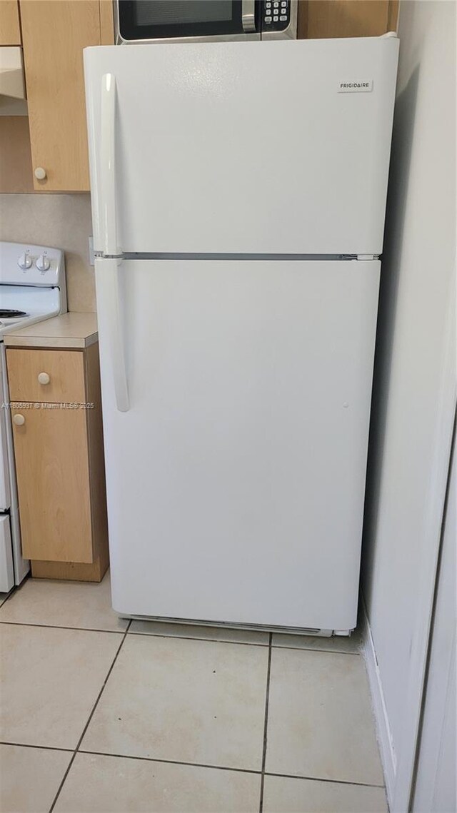 2921 SE 13th Ave Unit 106-48, Homestead, FL 33035 - kitchen featuring white appliances, exhaust hood, light tile patterned flooring, and light countertops