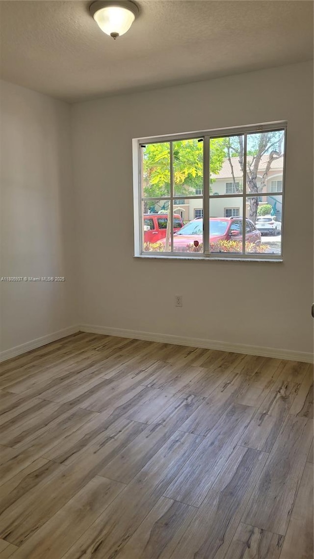 2921 SE 13th Ave Unit 106-48, Homestead, FL 33035 - spare room featuring healthy amount of natural light, wood finished floors, baseboards, and a textured ceiling