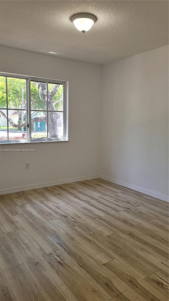 2921 SE 13th Ave Unit 106-48, Homestead, FL 33035 - empty room with hardwood / wood-style floors, a textured ceiling, and baseboards