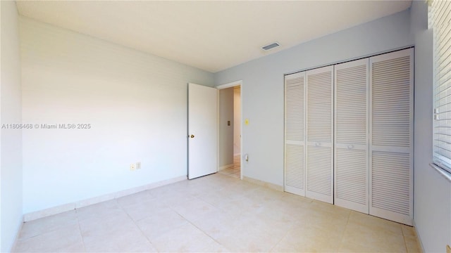 9936 SW 155th St, Miami, FL 33157 - unfurnished bedroom featuring a closet, baseboards, and light tile patterned floors