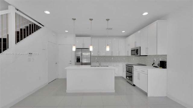 2621 NE 212th Ter Unit 209, Miami, FL 33180 - kitchen with stainless steel appliances, a sink, backsplash, white cabinets, and decorative light fixtures