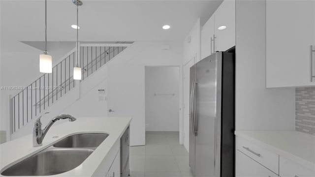 2621 NE 212th Ter Unit 209, Miami, FL 33180 - kitchen with appliances with stainless steel finishes, a sink, white cabinets, decorative light fixtures, and light countertops