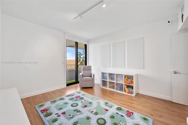 520 Brickell Key Dr Unit A604, Miami, FL 33131 - playroom featuring rail lighting, wood finished floors, and baseboards