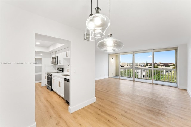 7051 Environ Blvd Unit 633, Lauderhill, FL 33319 - kitchen with appliances with stainless steel finishes, a chandelier, white cabinets, light wood-type flooring, and light countertops
