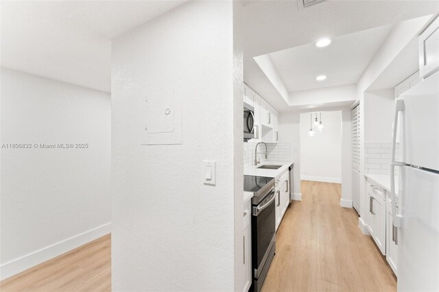 7051 Environ Blvd Unit 633, Lauderhill, FL 33319 - kitchen featuring appliances with stainless steel finishes, light countertops, white cabinets, light wood-style floors, and recessed lighting