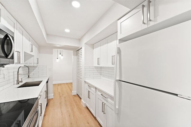 7051 Environ Blvd Unit 633, Lauderhill, FL 33319 - kitchen with freestanding refrigerator, stainless steel microwave, light countertops, recessed lighting, and white cabinets
