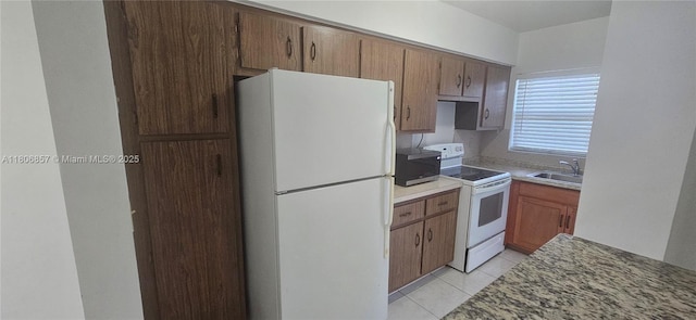 141 NE 10th Ave Unit 22C, Hallandale Beach, FL 33009 - kitchen with white appliances, a sink, and light tile patterned floors