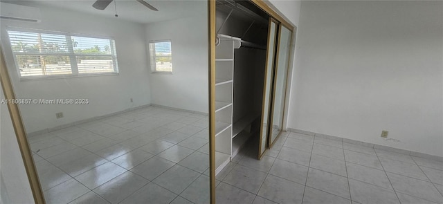141 NE 10th Ave Unit 22C, Hallandale Beach, FL 33009 - unfurnished bedroom with a wall mounted air conditioner, tile patterned flooring, a closet, and ceiling fan