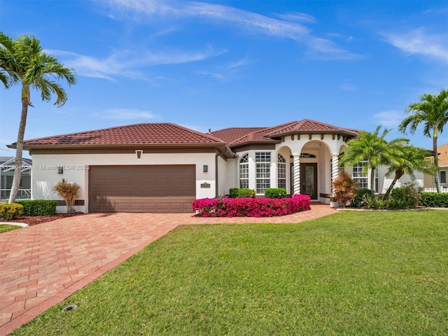 249 SW 37th Ln, Cape Coral, FL 33914 - mediterranean / spanish house with a garage, decorative driveway, a front yard, stucco siding, and a tile roof