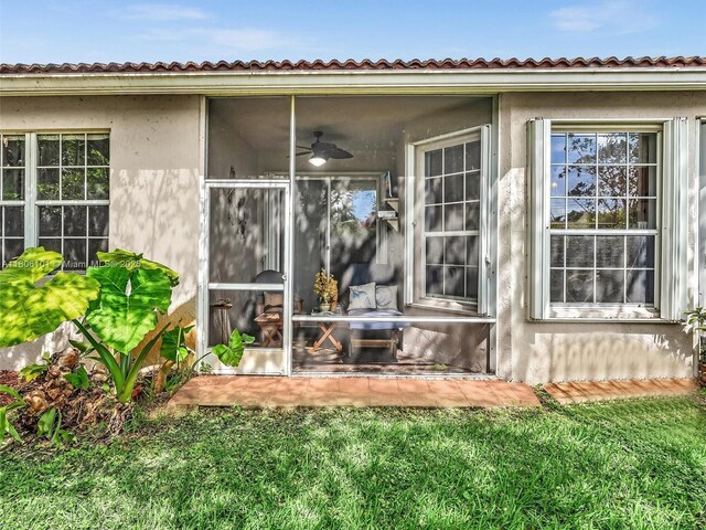 2530 E Aragon Blvd Unit 1, Sunrise, FL 33313 - back of property featuring stucco siding, a sunroom, and a lawn