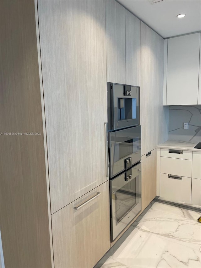 15701 Collins Ave Unit 1603, Sunny Isles Beach, FL 33160 - kitchen with light countertops, modern cabinets, light marble finish floors, recessed lighting, and white cabinets
