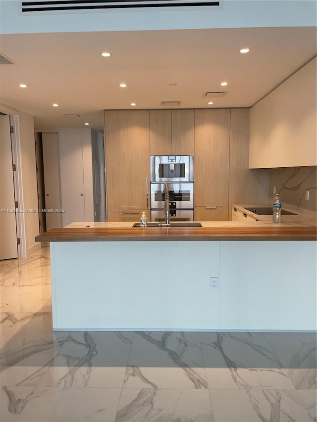 15701 Collins Ave Unit 1603, Sunny Isles Beach, FL 33160 - kitchen featuring light marble finish flooring, a sink, recessed lighting, modern cabinets, and a peninsula