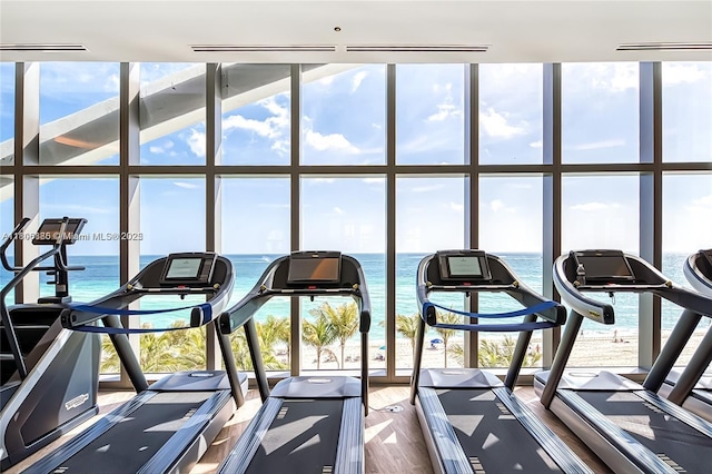 15701 Collins Ave Unit 1603, Sunny Isles Beach, FL 33160 - gym featuring expansive windows, a water view, and dark wood-type flooring