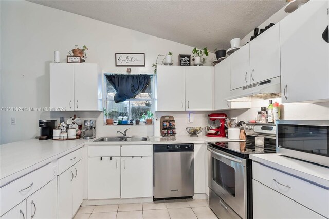 14226 SW 90th Ter, Miami, FL 33186 - kitchen featuring under cabinet range hood, stainless steel appliances, a sink, light countertops, and lofted ceiling