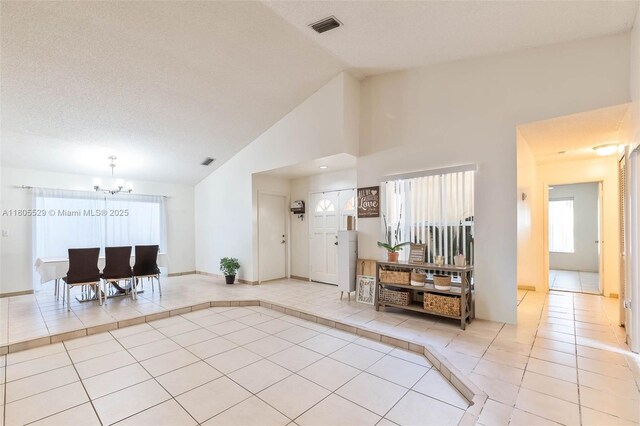 14226 SW 90th Ter, Miami, FL 33186 - foyer entrance with light tile patterned flooring, a chandelier, high vaulted ceiling, and baseboards