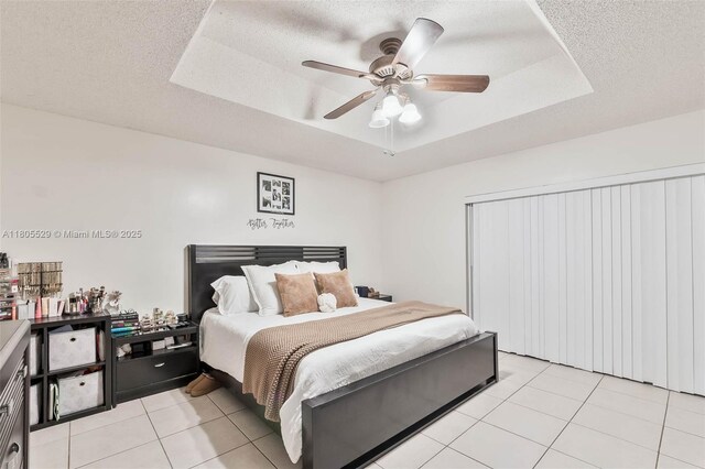 14226 SW 90th Ter, Miami, FL 33186 - bedroom with a raised ceiling, light tile patterned flooring, ceiling fan, and a textured ceiling