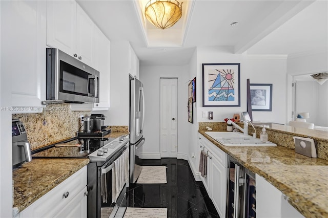 848 Brickell Key Dr Unit 3803, Miami, FL 33131 - kitchen with appliances with stainless steel finishes, a sink, granite floors, beverage cooler, and white cabinets