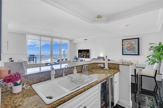 848 Brickell Key Dr Unit 3803, Miami, FL 33131 - kitchen with beverage cooler, a sink, white cabinetry, granite tiled floors, and light stone counters