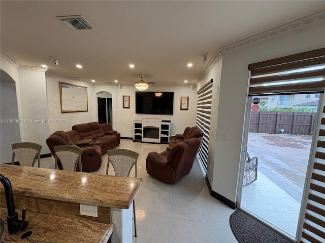 15375 SW 93rd Ln, Miami, FL 33196 - living room with light tile patterned floors, arched walkways, recessed lighting, crown molding, and a fireplace