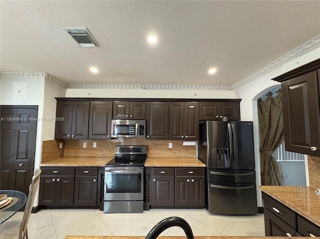 15375 SW 93rd Ln, Miami, FL 33196 - kitchen featuring stainless steel appliances, light tile patterned flooring, backsplash, and dark brown cabinetry