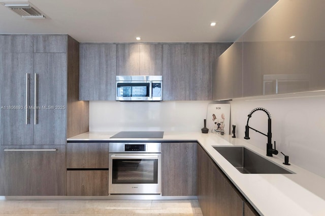 88 SW 7th St Unit 2707, Miami, FL 33130 - kitchen featuring stainless steel appliances, modern cabinets, a sink, light countertops, and recessed lighting