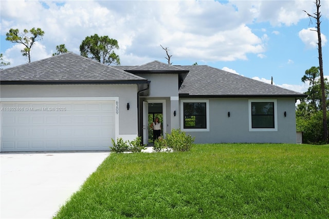 9016 E Justice Cir, La Belle, FL 33935 - view of front of home with roof with shingles, stucco siding, a front lawn, driveway, and an attached garage