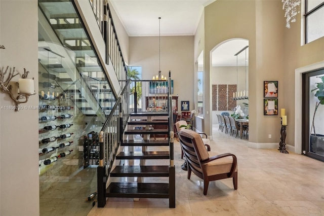 11898 SW 74th Ter, Miami, FL 33183 - foyer featuring arched walkways, a high ceiling, a chandelier, stairway, and crown molding