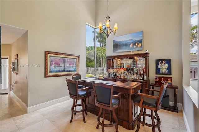 11898 SW 74th Ter, Miami, FL 33183 - indoor dry bar featuring a high ceiling, a chandelier, baseboards, and decorative light fixtures