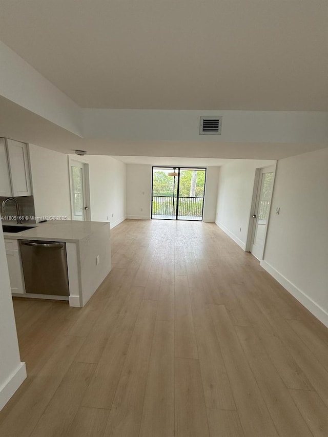 5570 NW 44th St Unit 209A, Lauderhill, FL 33319 - unfurnished living room featuring a sink, light wood-style flooring, and baseboards
