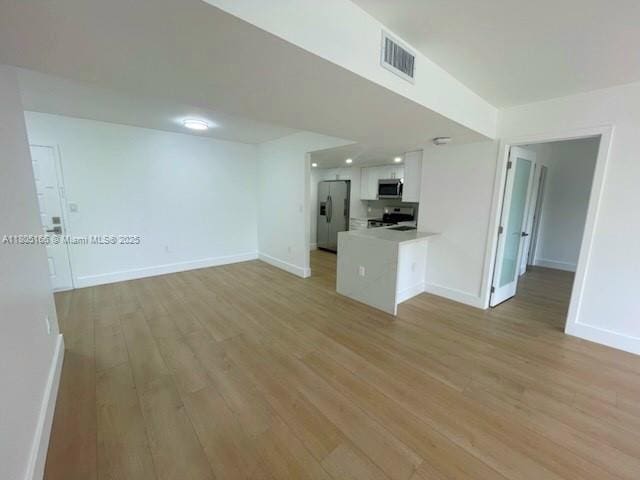 5570 NW 44th St Unit 209A, Lauderhill, FL 33319 - unfurnished living room with light wood-style floors and recessed lighting