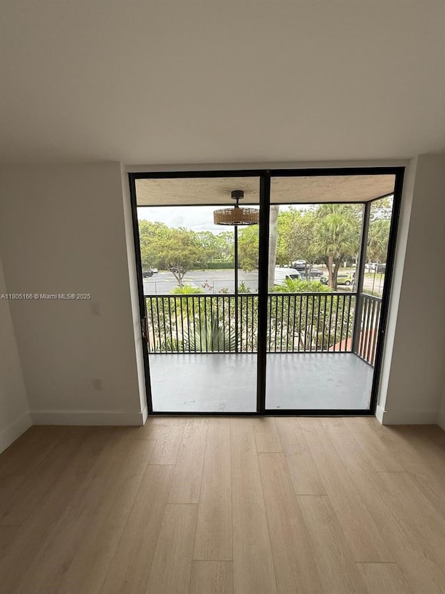 5570 NW 44th St Unit 209A, Lauderhill, FL 33319 - empty room featuring expansive windows, wood finished floors, baseboards, and healthy amount of natural light
