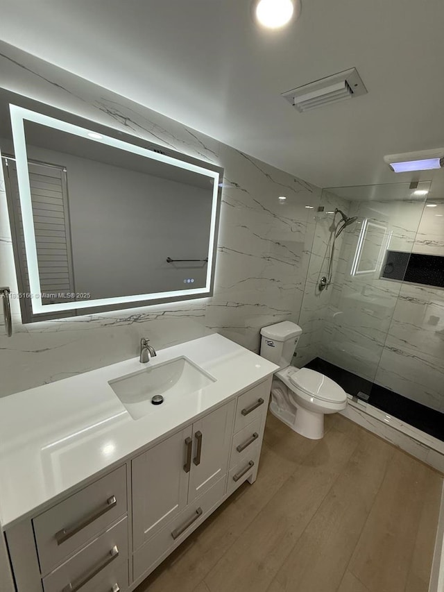5570 NW 44th St Unit 209A, Lauderhill, FL 33319 - full bathroom with a marble finish shower, vanity, toilet, wood finished floors, and tile walls