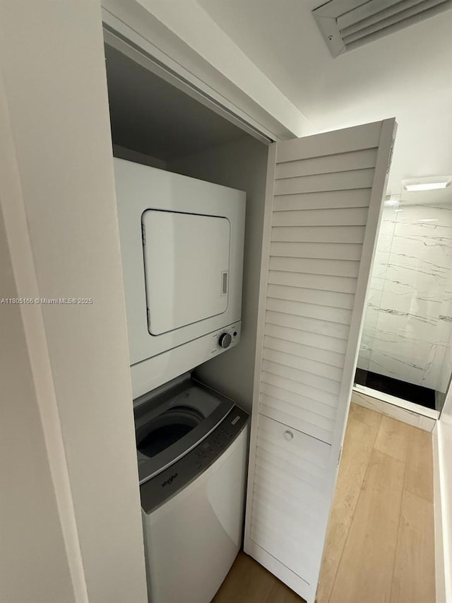 5570 NW 44th St Unit 209A, Lauderhill, FL 33319 - washroom with stacked washer and clothes dryer and wood finished floors