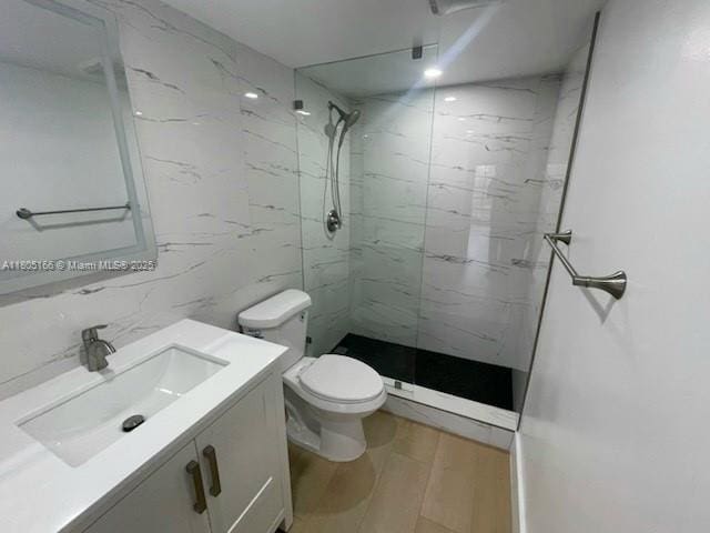 5570 NW 44th St Unit 209A, Lauderhill, FL 33319 - full bathroom featuring a marble finish shower, vanity, wood finished floors, and tile walls
