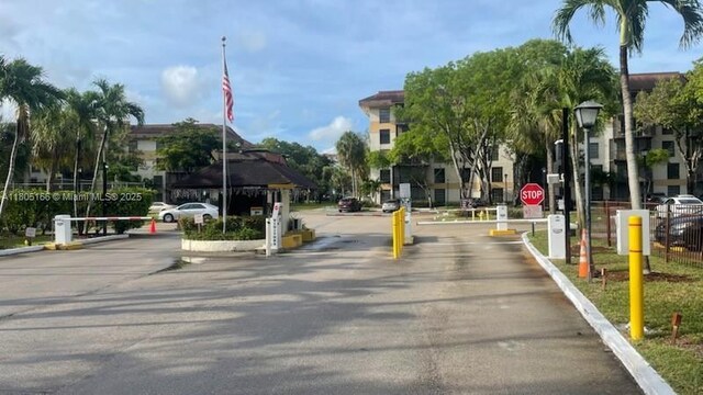 5570 NW 44th St Unit 209A, Lauderhill, FL 33319 - view of asphalt street featuring traffic signs, a gated entry, street lights, and curbs