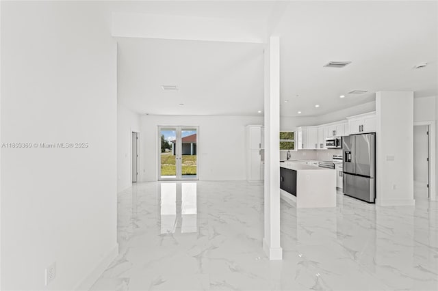 2506 5th St SW, Lehigh Acres, FL 33976 - unfurnished living room with light marble finish floors, baseboards, a sink, and recessed lighting