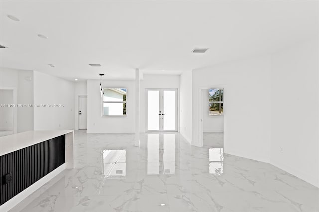 2506 5th St SW, Lehigh Acres, FL 33976 - spare room with light marble finish flooring, french doors, plenty of natural light, and baseboards