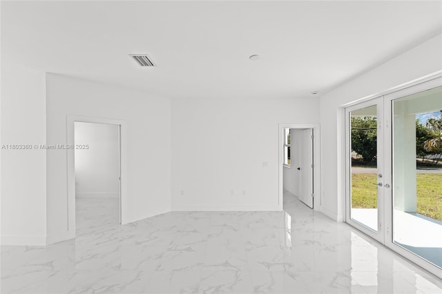 2506 5th St SW, Lehigh Acres, FL 33976 - empty room featuring baseboards, light marble finish flooring, and french doors