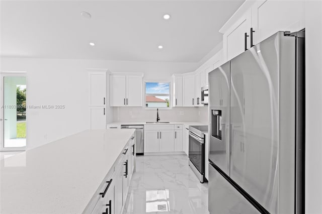 2506 5th St SW, Lehigh Acres, FL 33976 - kitchen with appliances with stainless steel finishes, a sink, white cabinetry, recessed lighting, and light marble finish flooring