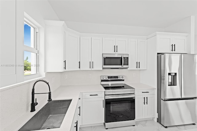 2506 5th St SW, Lehigh Acres, FL 33976 - kitchen with appliances with stainless steel finishes, light marble finish flooring, white cabinets, and a sink