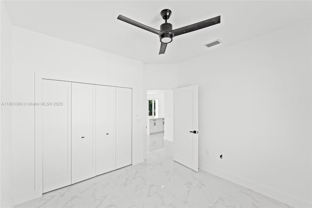 2506 5th St SW, Lehigh Acres, FL 33976 - unfurnished bedroom with light marble finish flooring, a closet, baseboards, and ceiling fan